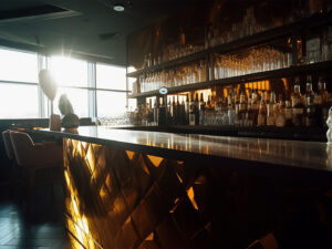 Midjourney, fancy bar counter with liquor bottles, golden light